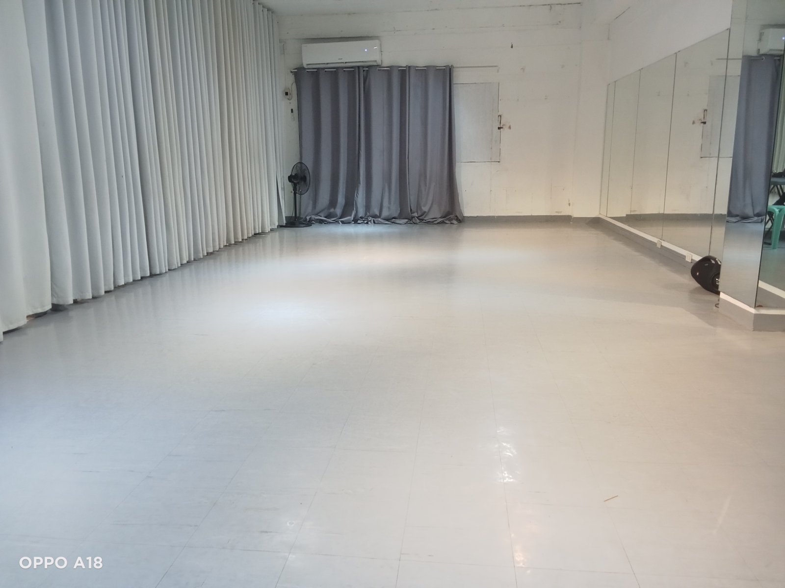 A spacious dance studio with hardwood floors and large mirrors.